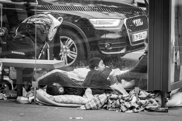 Une famille utilise un abribus comme abri à Paris.