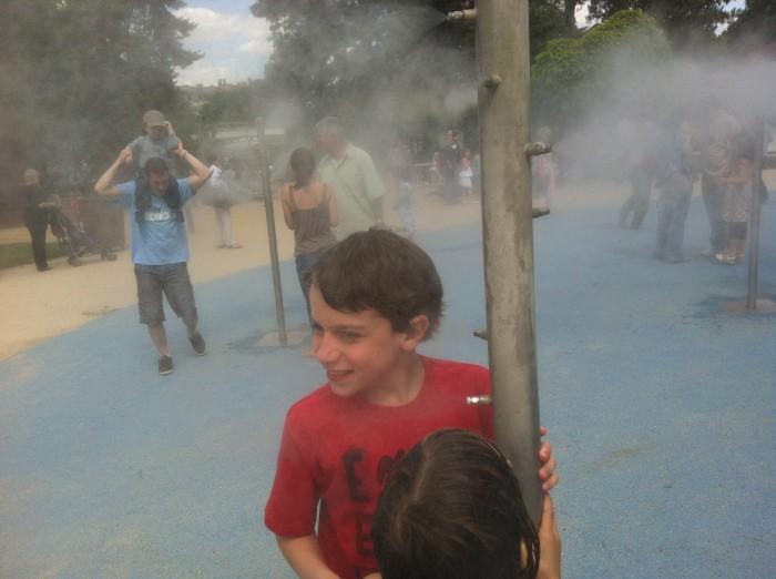 Lors des chauds jours d'été, les enfants s'amusent avec de l'eau vaporisée